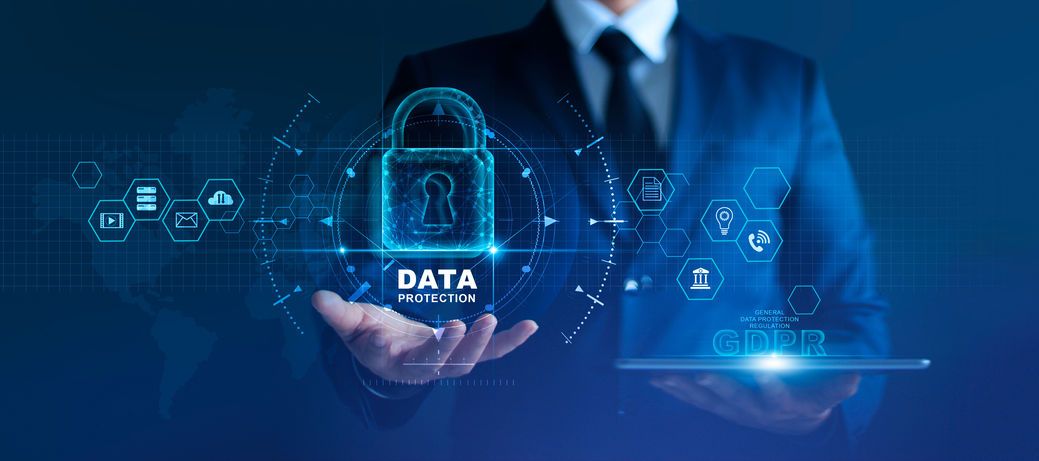 Businessman presents virtual padlock labeled “data protection” above floating digital tablet interface.