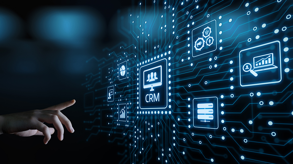Hand reaches to select central CRM icon on futuristic circuit board interface.